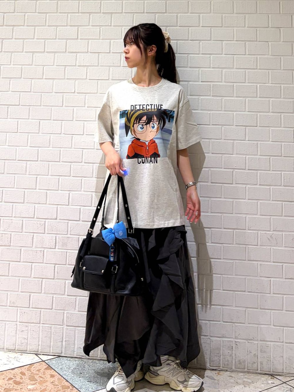グレー系のスカート、ブラック系のボストンバッグ、ホワイト系のTシャツ/カットソーを着用したレディースの春コーディネートの5枚目の写真