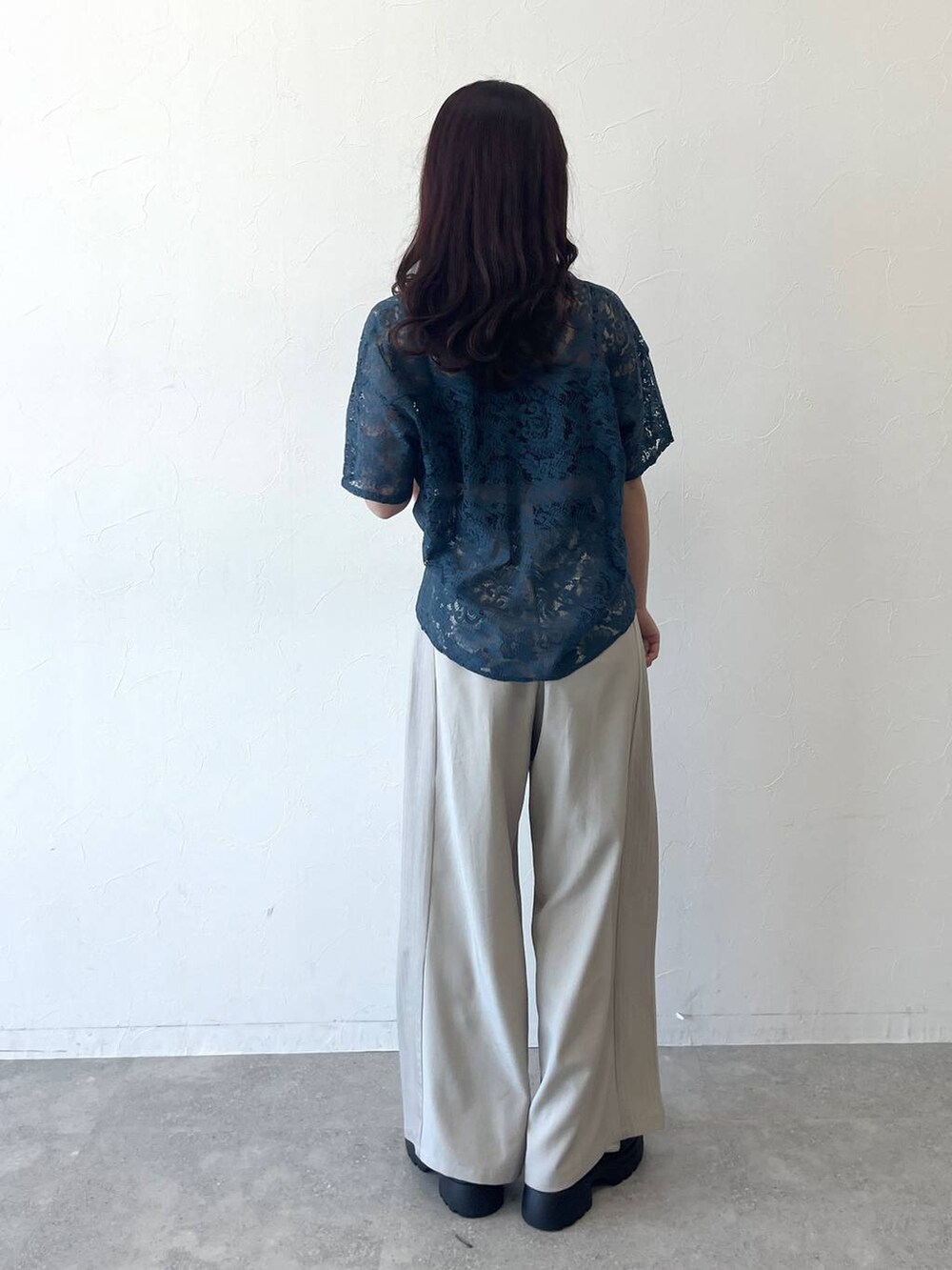 グリーン系のシャツ/ブラウス、ベージュ系のスラックス、ブラック系のベルトを着用したレディースの春コーディネートの3枚目の写真