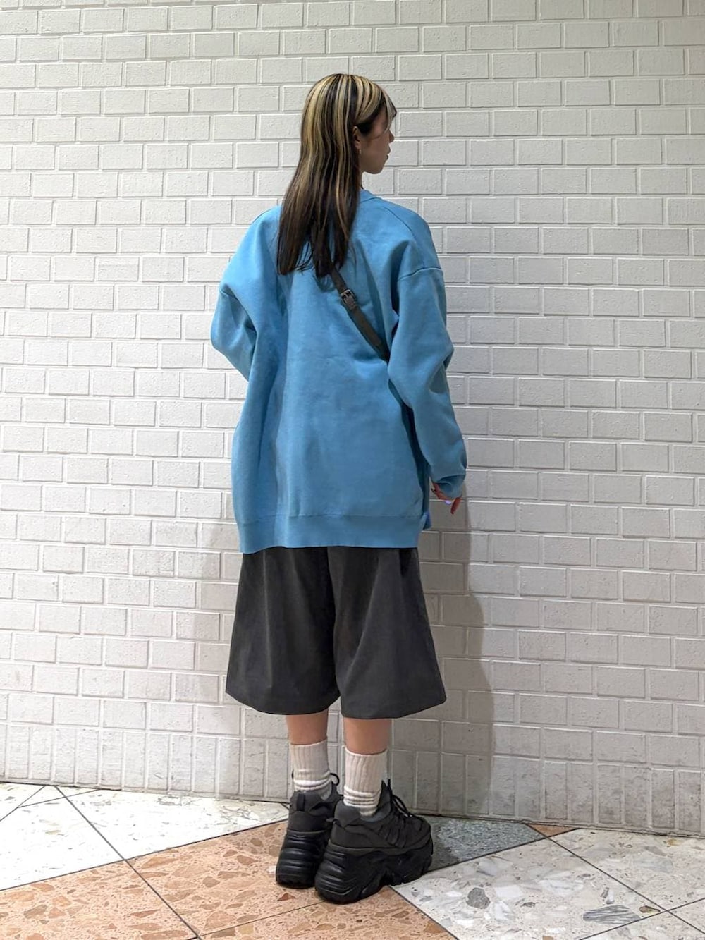 グレー系のスニーカー、グレー系のショルダーバッグ、グレー系のスラックスを着用したレディースの春コーディネートの3枚目の写真