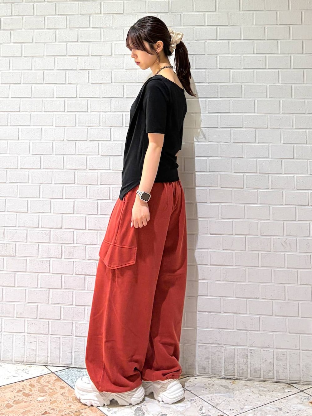ホワイト系のスニーカー、レッド系のその他パンツ、ブラック系のTシャツ/カットソーを着用したレディースの春コーディネートの3枚目の写真