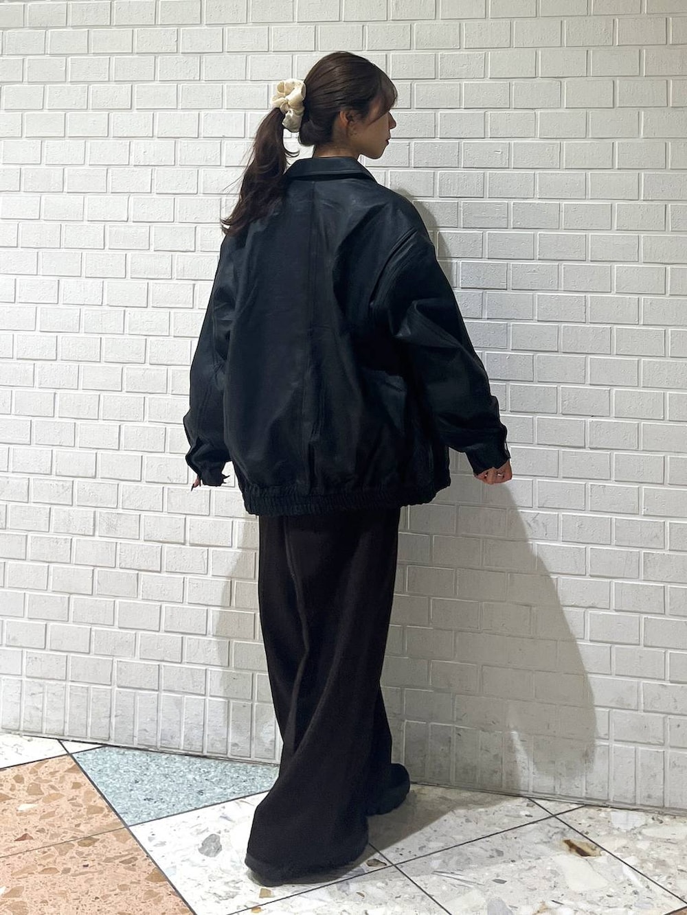 ブラック系のスニーカー、ブラック系のブルゾン、ホワイト系のカーディガン/ボレロを着用したレディースの秋コーディネートの7枚目の写真