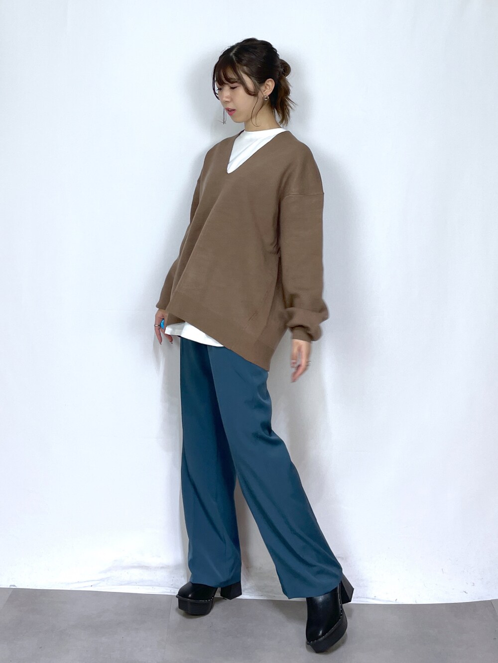ホワイト系のTシャツ/カットソー、ブラウン系のニット/セーター、ブルー系のスラックスを着用したレディースの冬コーディネートの2枚目の写真