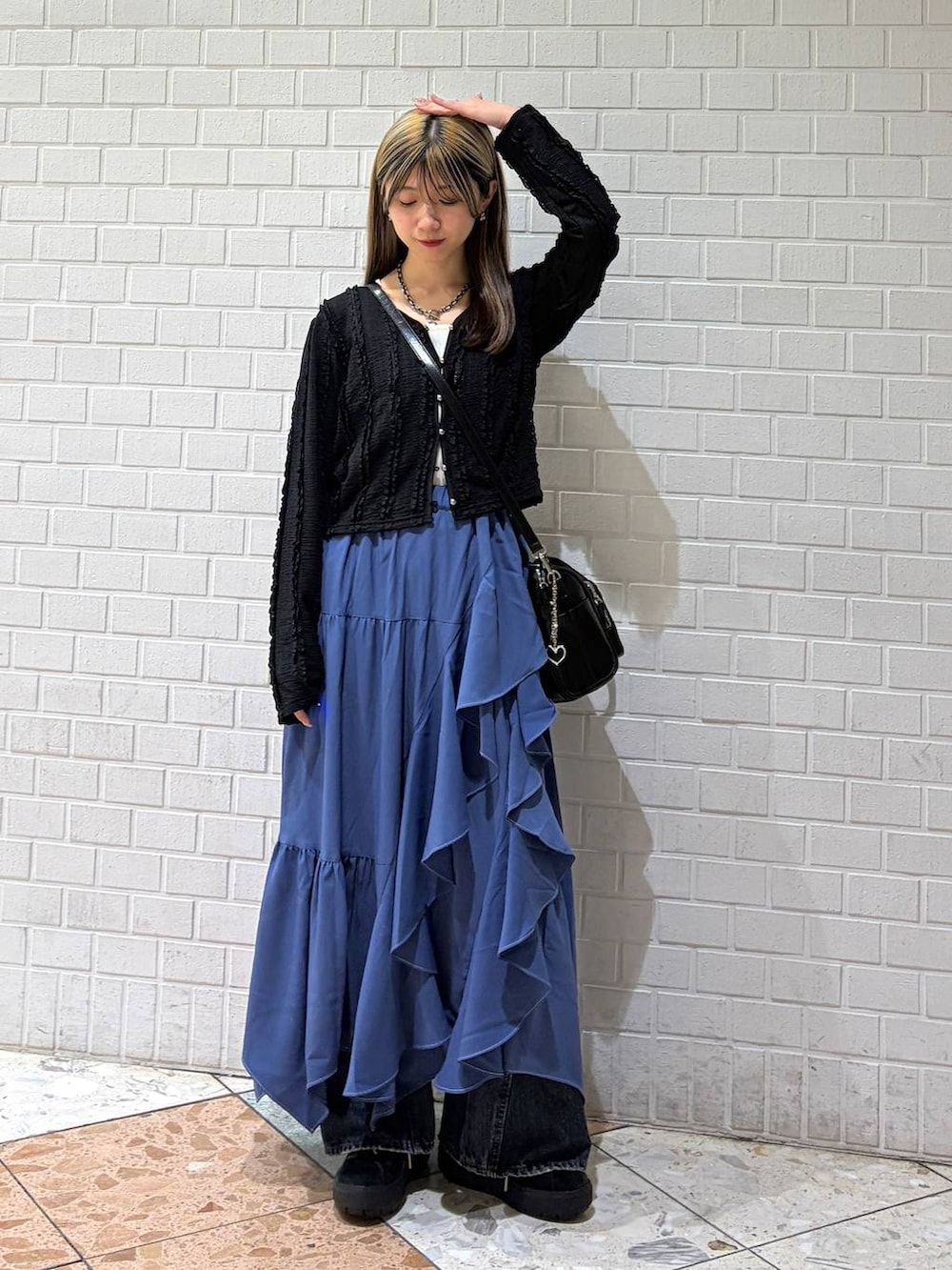 ブルー系のデニムパンツ、ブルー系のスカート、ブラック系のショルダーバッグを着用したレディースの春コーディネートの4枚目の写真