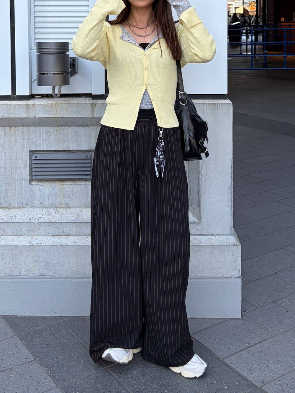 ブラック系のスラックス、グレー系のTシャツ/カットソーを着用したレディースの春コーディネートの3枚目の写真