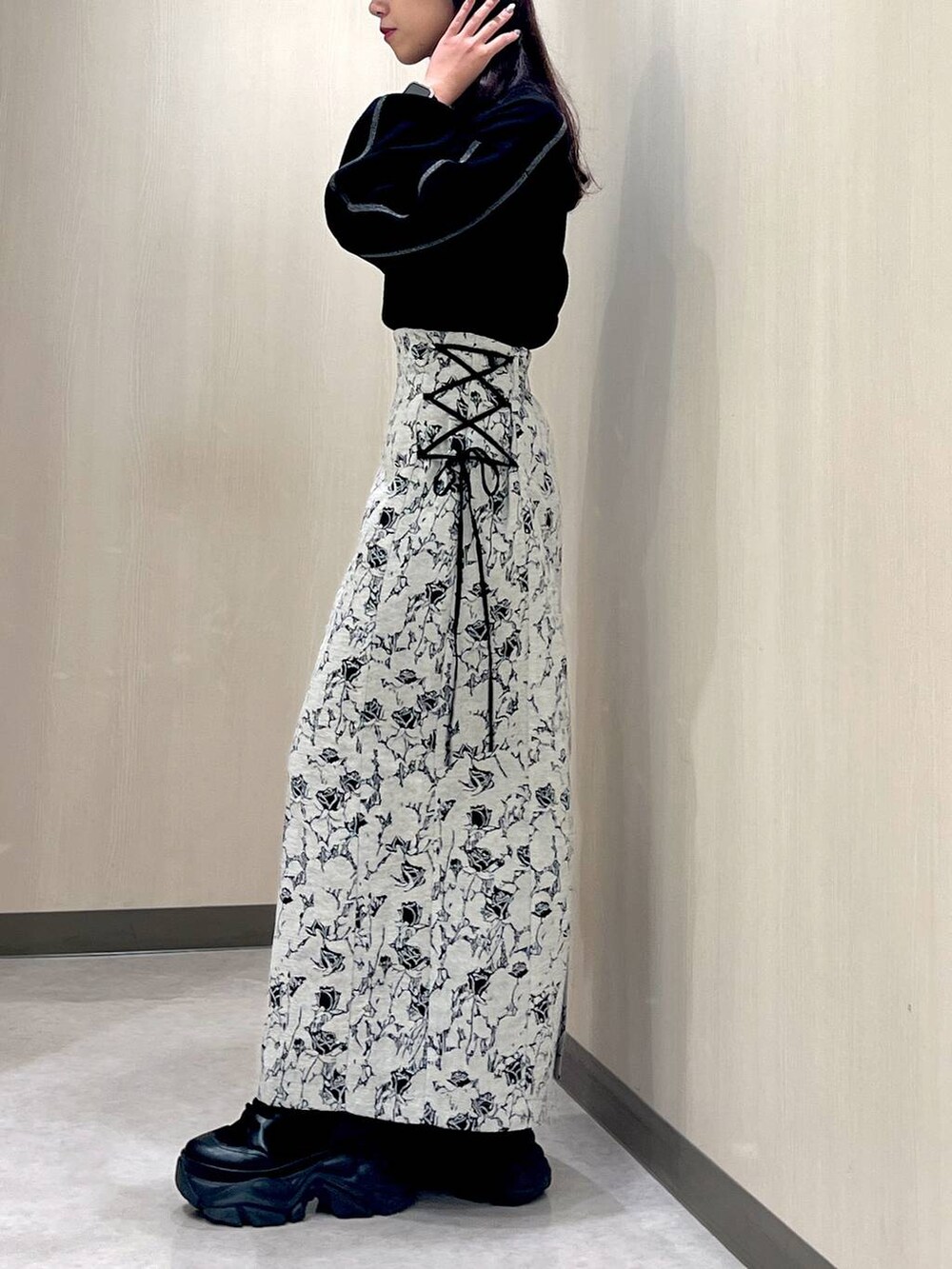 ブラック系のブーツ、ホワイト系のカーディガン/ボレロ、ブラック系のニット/セーターを着用したレディースの秋コーディネートの4枚目の写真