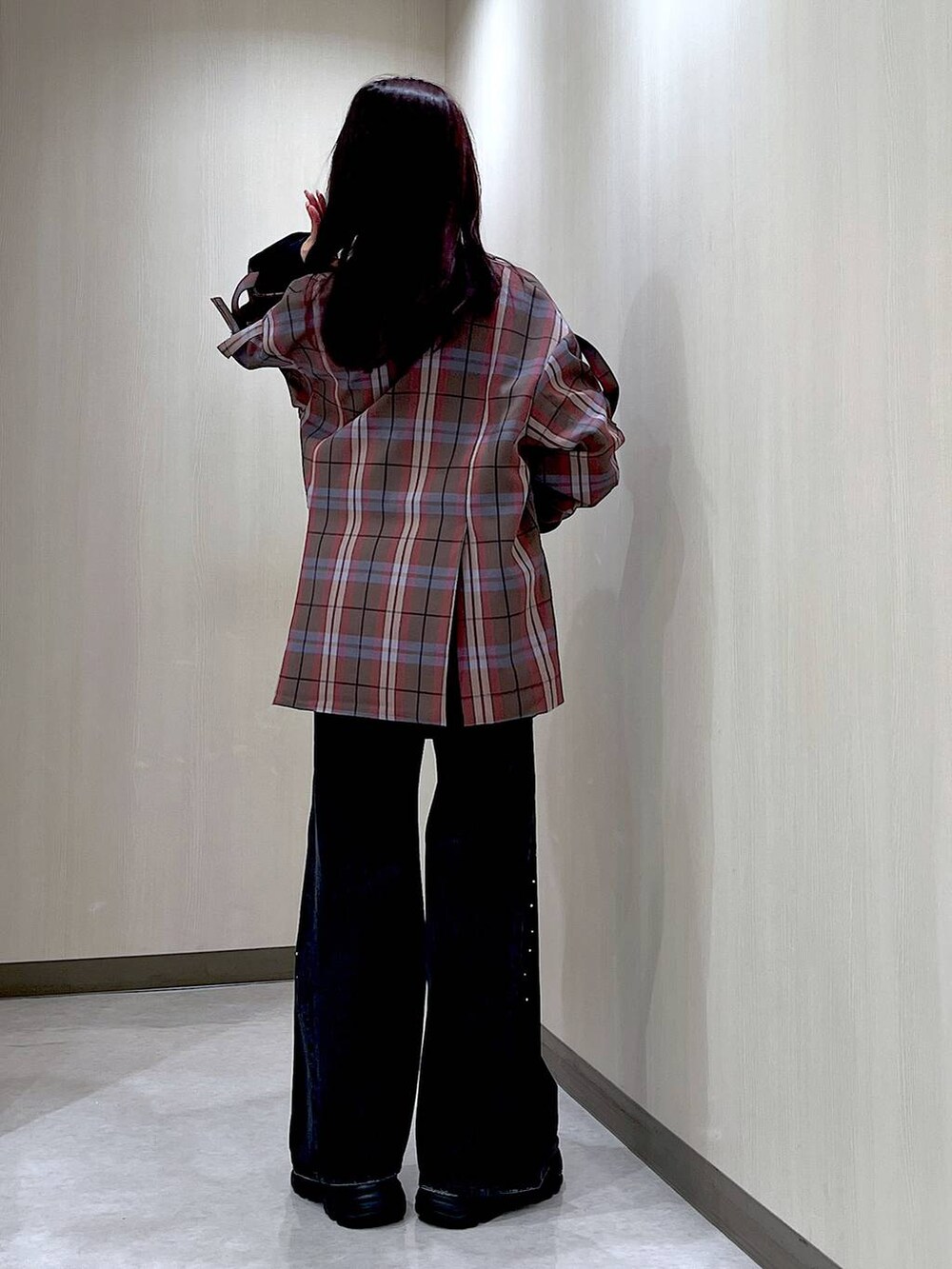 ブラック系のデニムパンツ、ブラック系のブーツ、ブラウン系のテーラードジャケットを着用したレディースの秋コーディネートの3枚目の写真