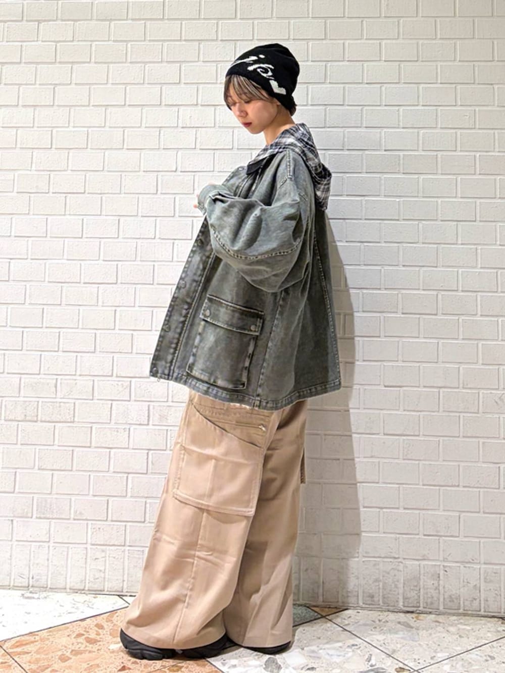 ブラック系のブーツ、ベージュ系のスラックス、ブラック系のシャツ/ブラウスを着用したレディースの春コーディネートの5枚目の写真