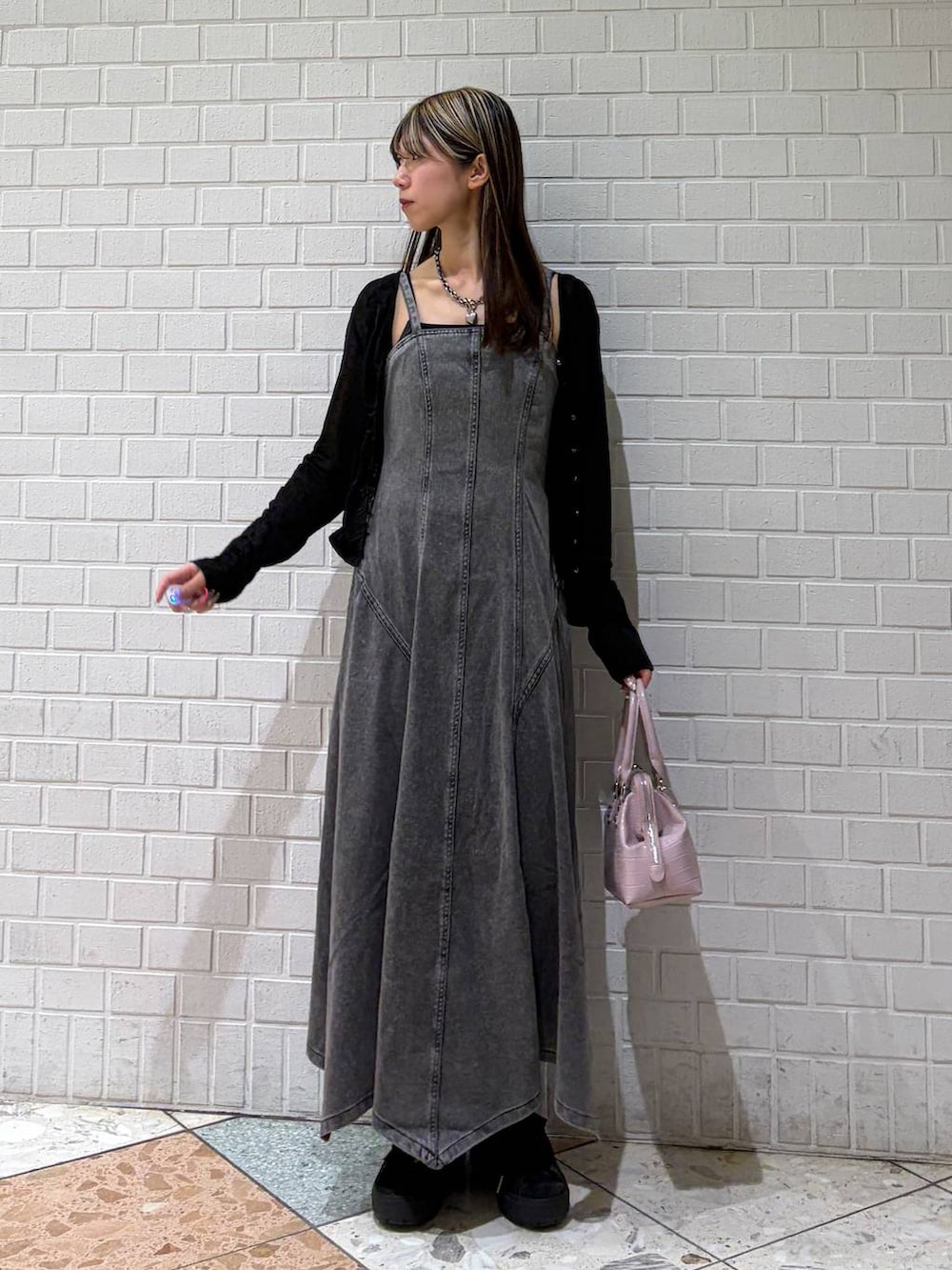 ピンク系のハンドバッグ、ブラック系のワンピース、ブラック系のTシャツ/カットソーを着用したレディースの春コーディネートの7枚目の写真