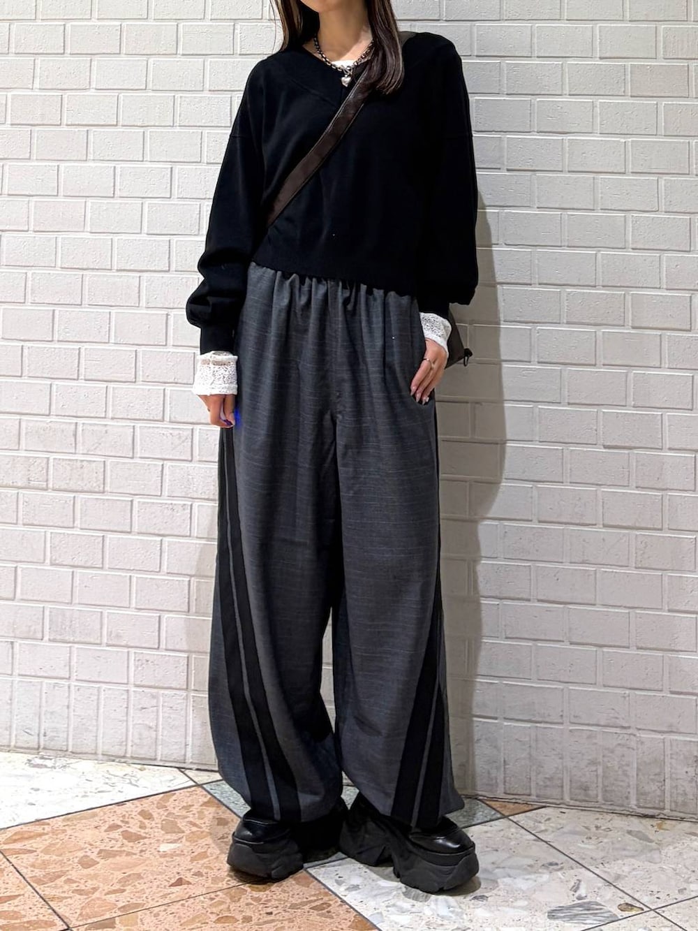 ブラック系のブーツ、ブラック系のニット/セーター、ブラウン系のショルダーバッグを着用したレディースの冬コーディネートの4枚目の写真