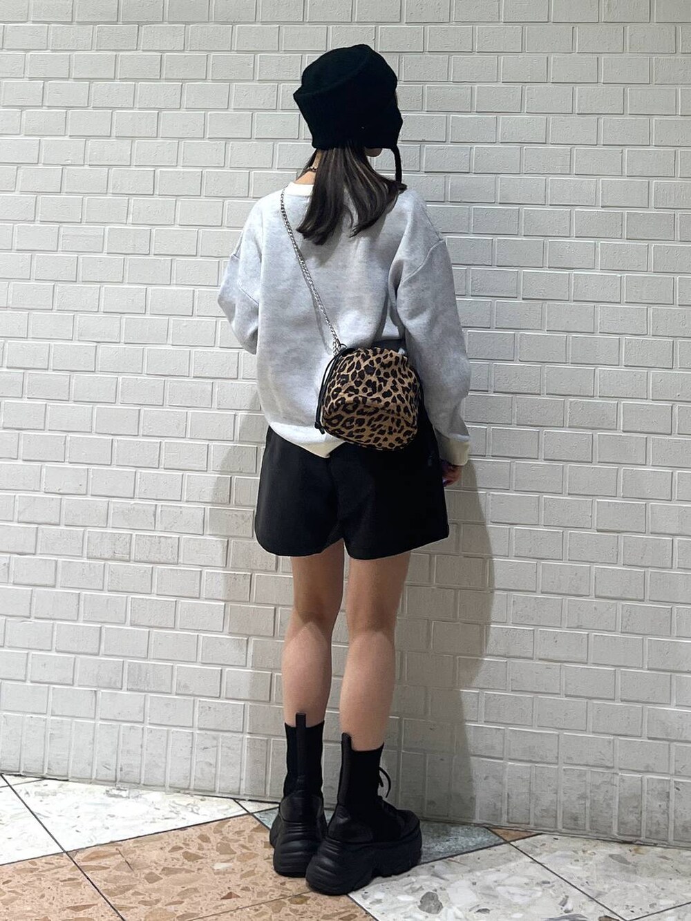 ブラック系のブーツ、ホワイト系のカーディガン/ボレロ、ホワイト系のニット/セーターを着用したレディースの冬コーディネートの8枚目の写真