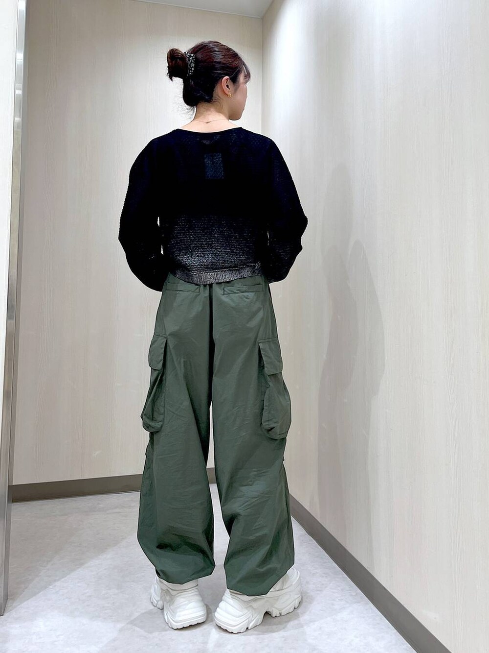 グリーン系のカーゴパンツ、ホワイト系のスニーカー、ブラック系のカーディガン/ボレロを着用したレディースの夏コーディネートの3枚目の写真