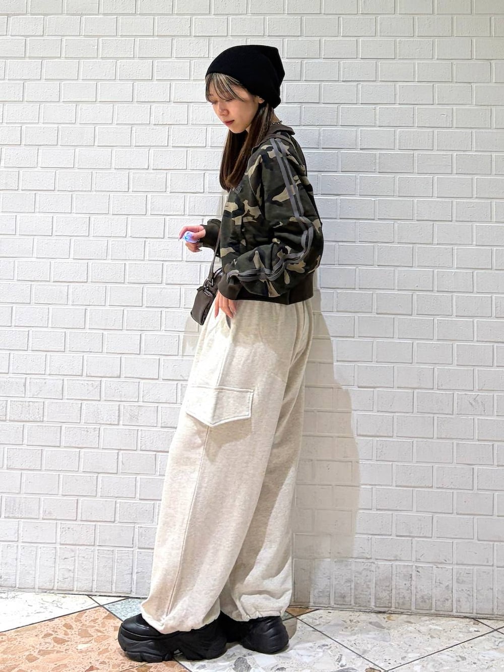 ブラック系のブーツ、ブラウン系のショルダーバッグ、グリーン系のジャージを着用したレディースの春コーディネートの5枚目の写真