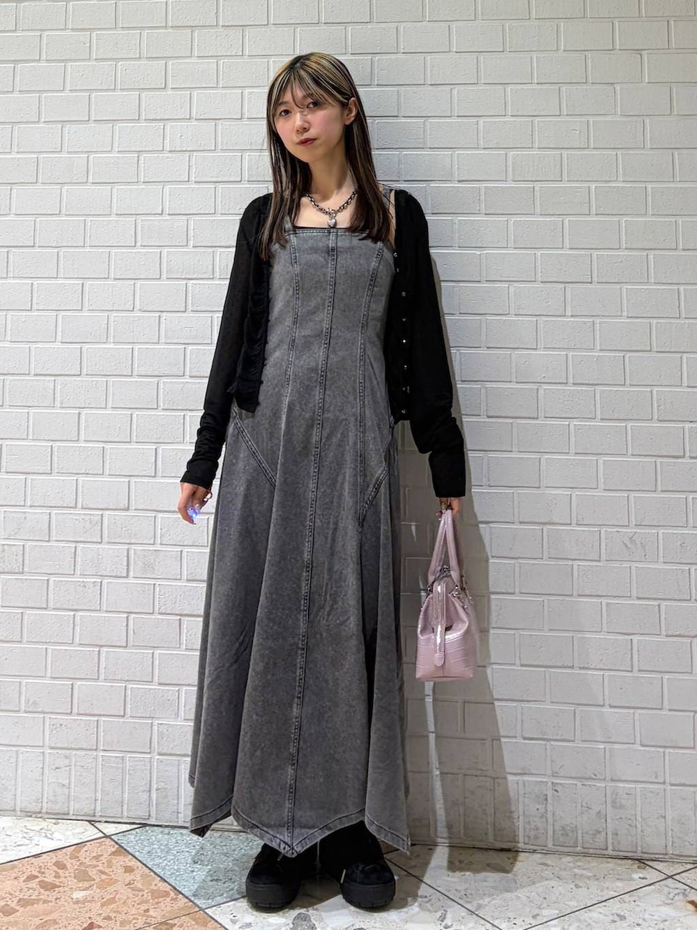 ピンク系のハンドバッグ、ブラック系のワンピース、ブラック系のTシャツ/カットソーを着用したレディースの春コーディネートの4枚目の写真