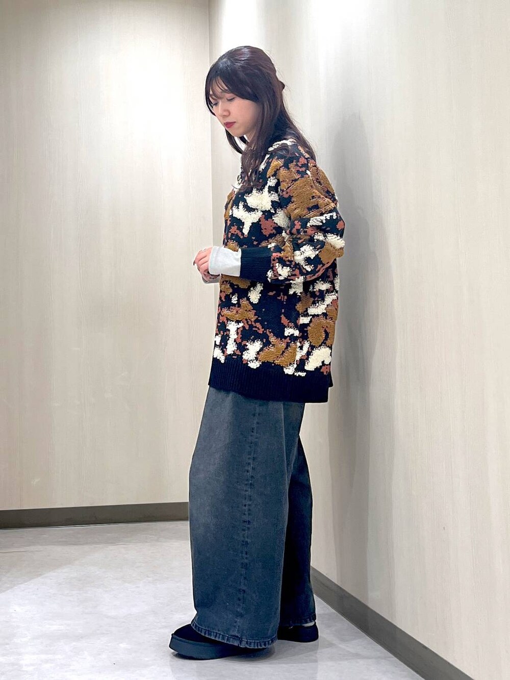 ブラック系のデニムパンツ、ブルー系のニット/セーター、ブラック系のネックレスを着用したレディースの冬コーディネートの2枚目の写真