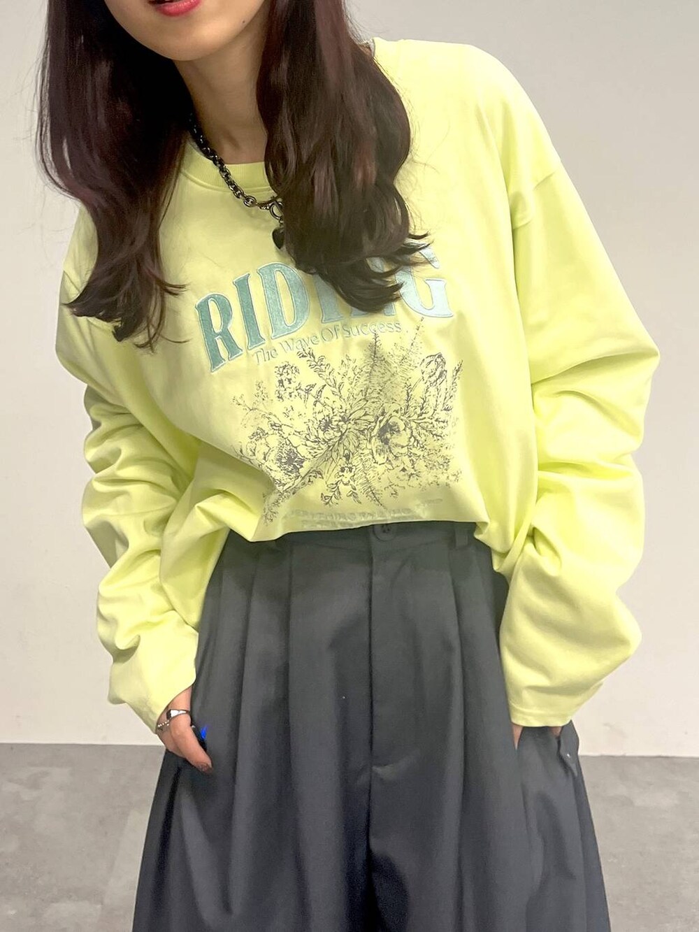 グレー系のカーゴパンツ、イエロー系のTシャツ/カットソー、ブラック系のネックレスを着用したレディースの冬コーディネートの5枚目の写真