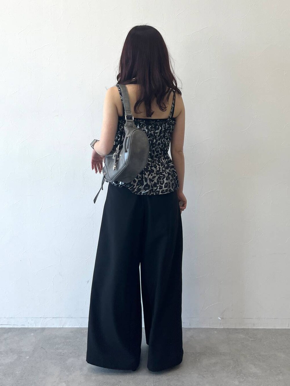 グレー系のショルダーバッグ、ブラック系のスラックスを着用したレディースの夏コーディネートの3枚目の写真