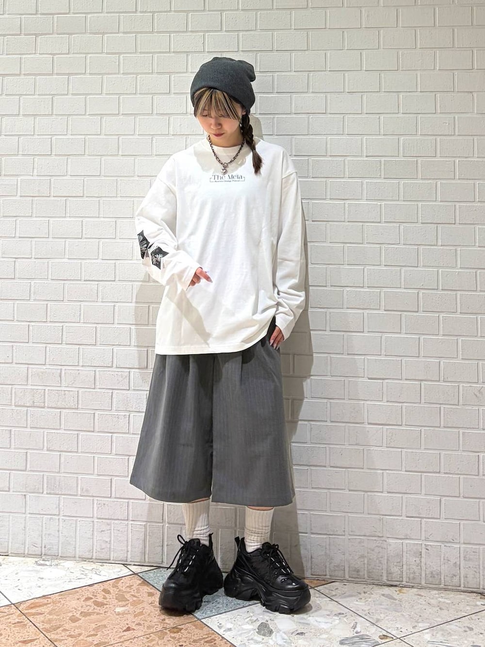 ブラック系のスニーカー、ホワイト系のTシャツ/カットソー、グレー系のスラックスを着用したレディースの春コーディネートの4枚目の写真