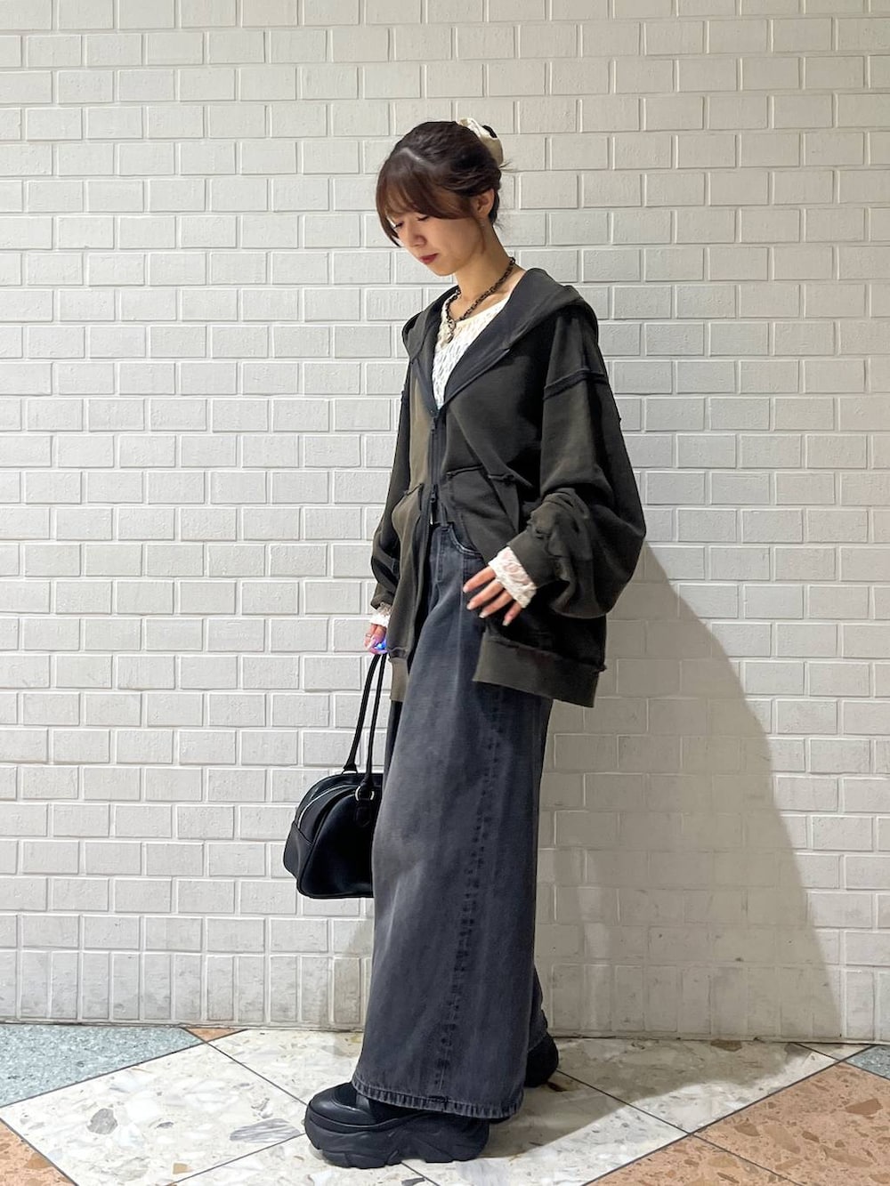 ブラック系のブーツ、ブラック系のデニムパンツ、ホワイト系のTシャツ/カットソーを着用したレディースの秋コーディネートの2枚目の写真