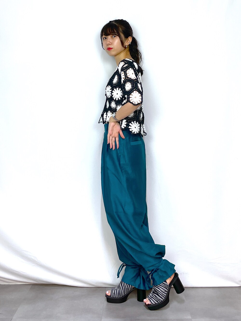 ブラック系のカーディガン/ボレロ、ブラック系のキャミソール、ブルー系のスラックスを着用したレディースの夏コーディネートの2枚目の写真