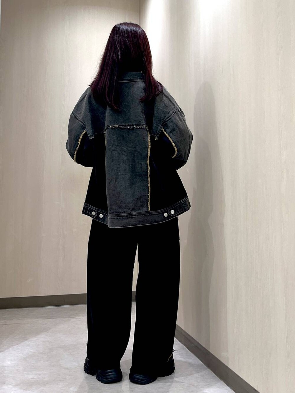 ブラック系のブーツ、ブラック系のデニムパンツ、ブラック系のブルゾンを着用したレディースの秋コーディネートの3枚目の写真