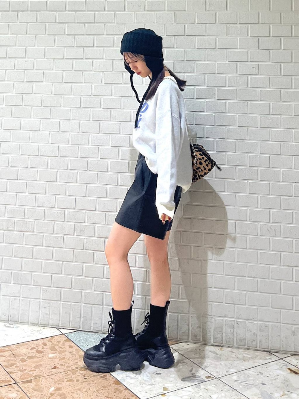 ブラック系のブーツ、ホワイト系のカーディガン/ボレロ、ホワイト系のニット/セーターを着用したレディースの冬コーディネートの7枚目の写真