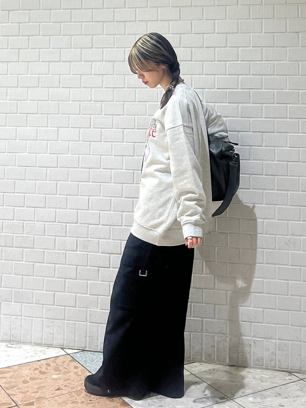 グリーン系のボストンバッグ、ブラック系のスラックス、グレー系のスウェットを着用したレディースの冬コーディネートの6枚目の写真