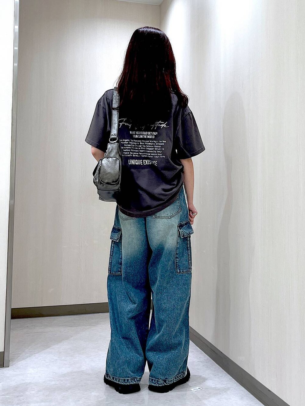 ブルー系のデニムパンツ、ブラック系のスニーカー、グレー系のTシャツ/カットソーを着用したレディースの秋コーディネートの2枚目の写真