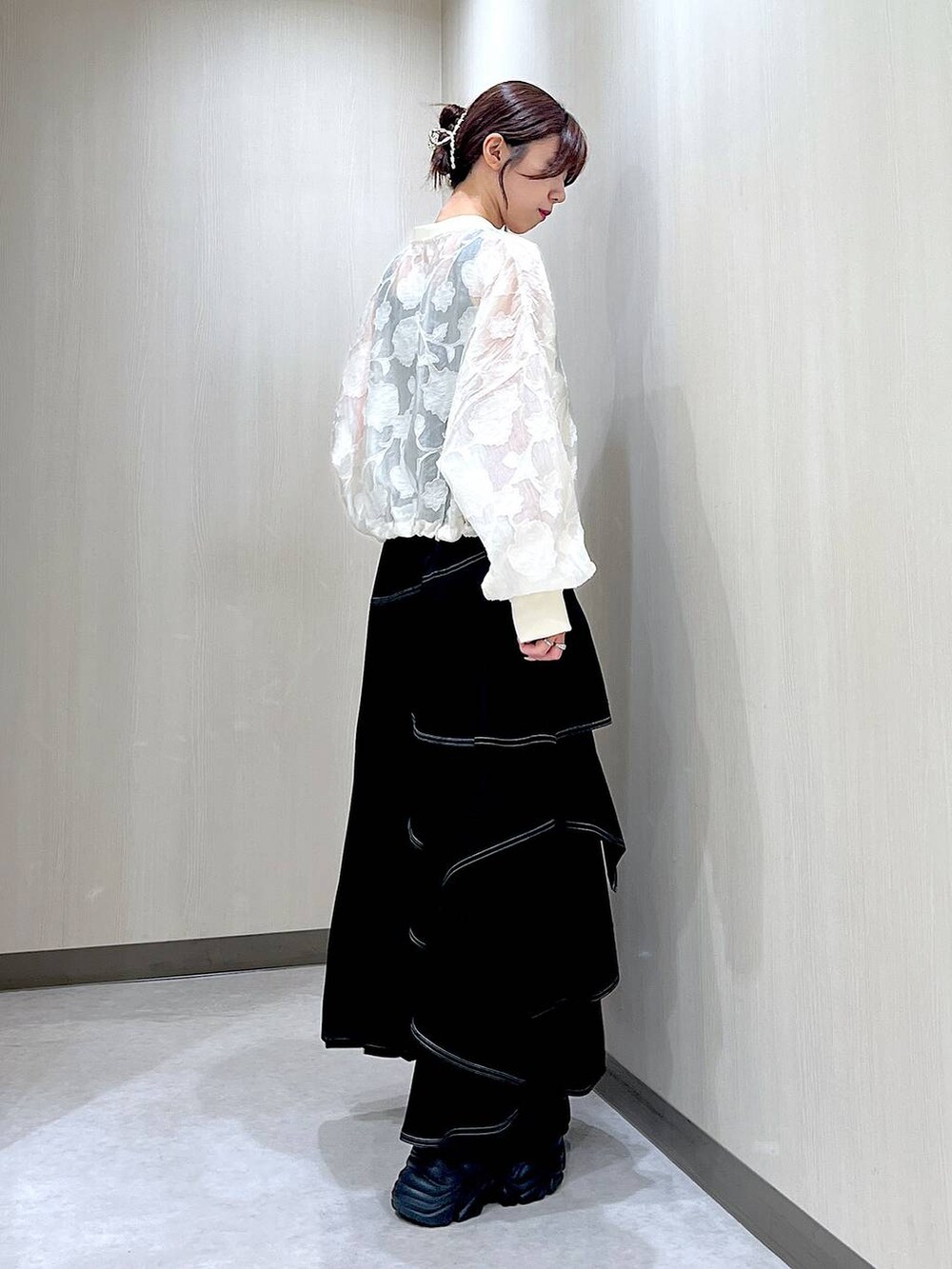 グレー系のタンクトップ、ホワイト系のブルゾン、ブラック系のブーツを着用したレディースの秋コーディネートの2枚目の写真
