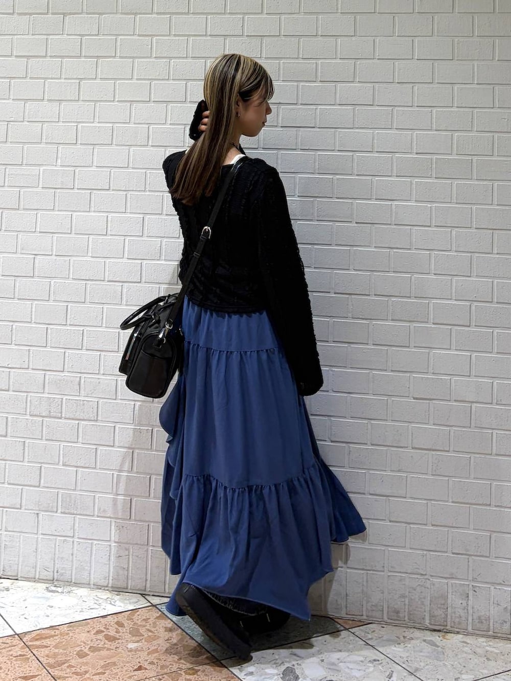 ブルー系のデニムパンツ、ブルー系のスカート、ブラック系のショルダーバッグを着用したレディースの春コーディネートの5枚目の写真