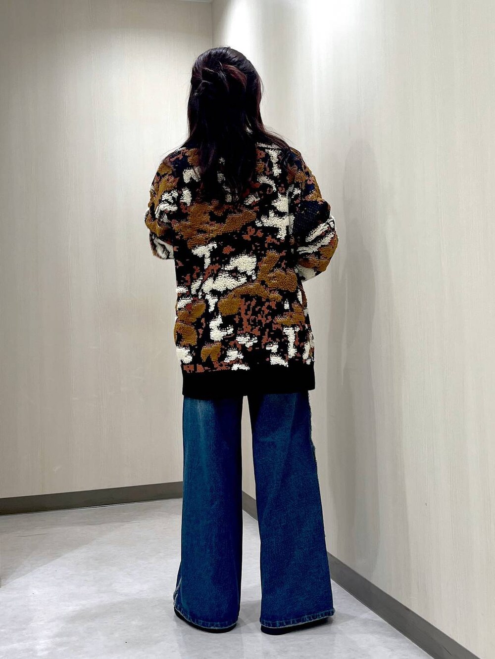 ブルー系のデニムパンツ、ブルー系のニット/セーター、ブラック系のネックレスを着用したレディースの冬コーディネートの3枚目の写真