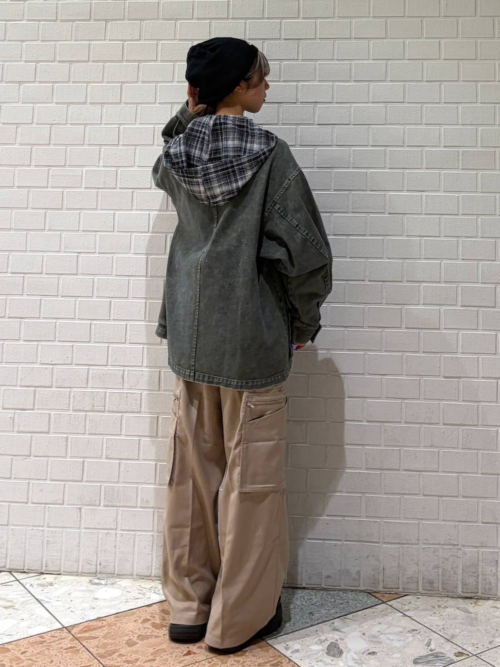 ブラック系のブーツ、ベージュ系のスラックス、ブラック系のシャツ/ブラウスを着用したレディースの春コーディネートの3枚目の写真