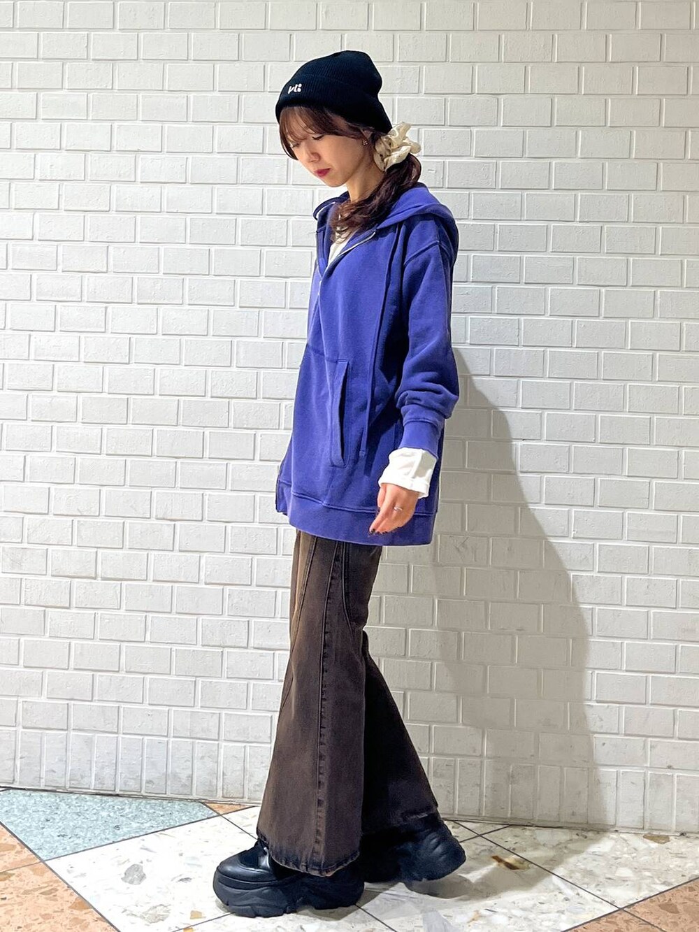 ブラック系のブーツ、ブラウン系のデニムパンツ、ブルー系のパーカーを着用したレディースの秋コーディネートの4枚目の写真