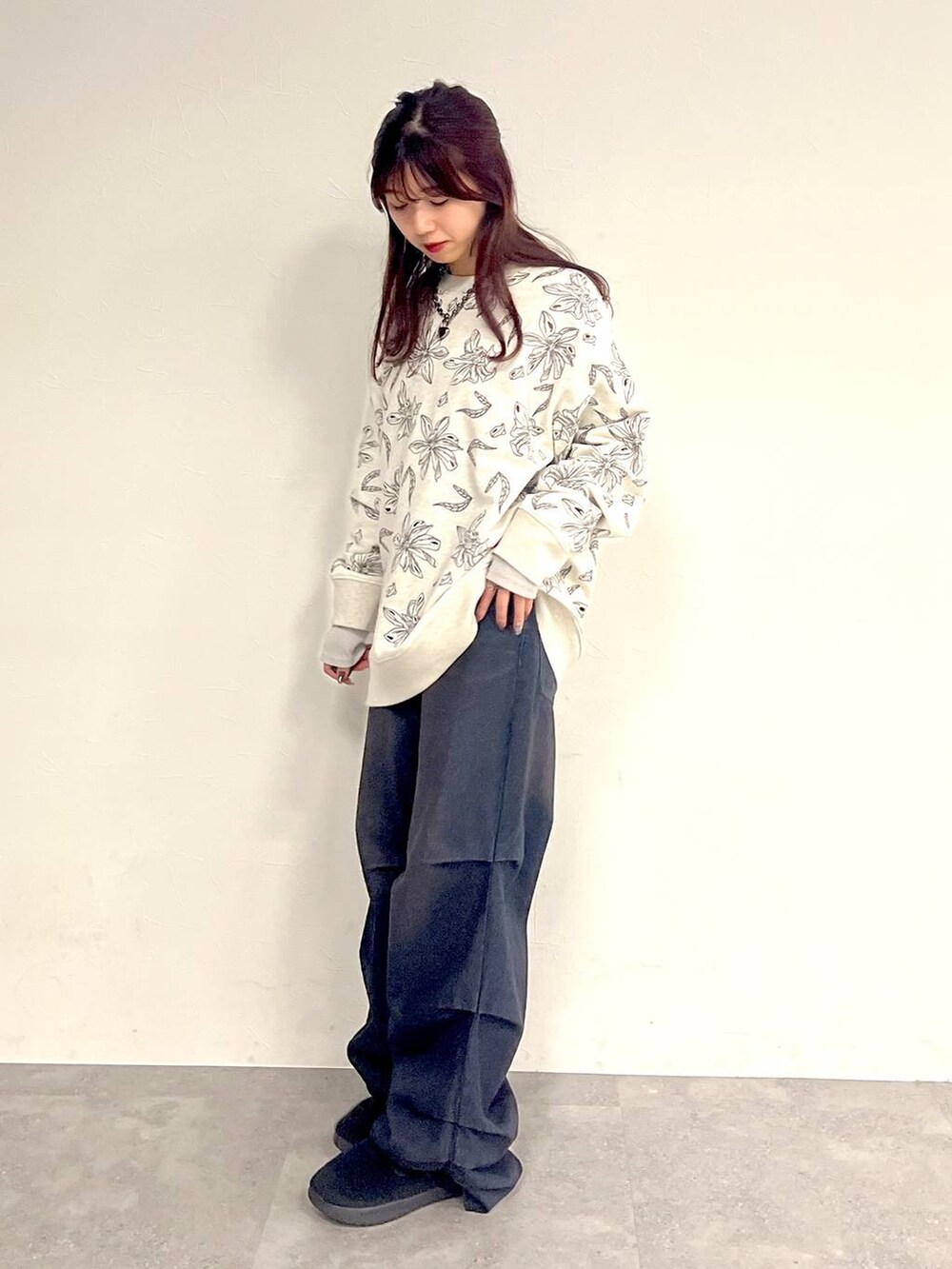 ブルー系のデニムパンツ、グレー系のスウェット、ブラック系のネックレスを着用したレディースの冬コーディネートの5枚目の写真