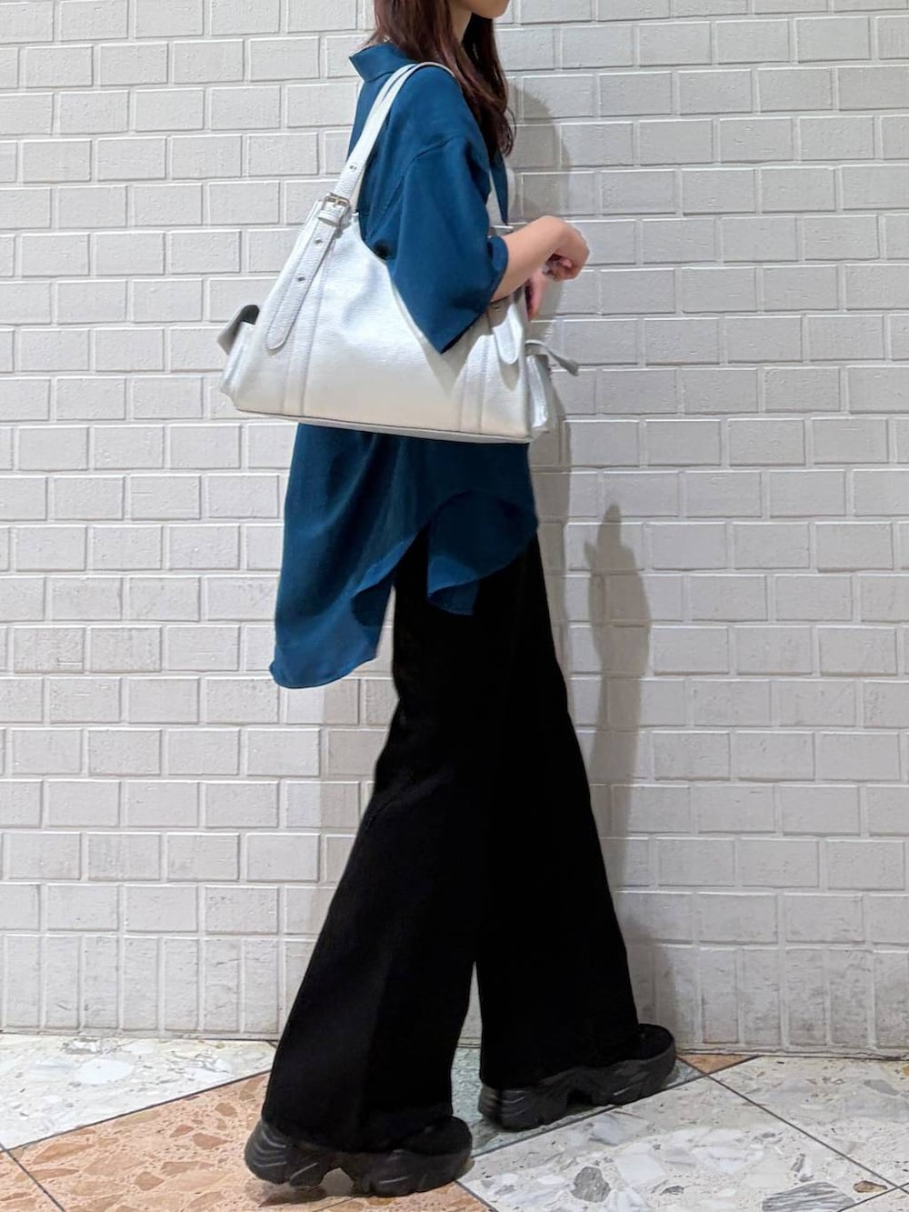 ブラック系のデニムパンツ、シルバー系のハンドバッグ、ブルー系のシャツ/ブラウスを着用したレディースの夏コーディネートの4枚目の写真