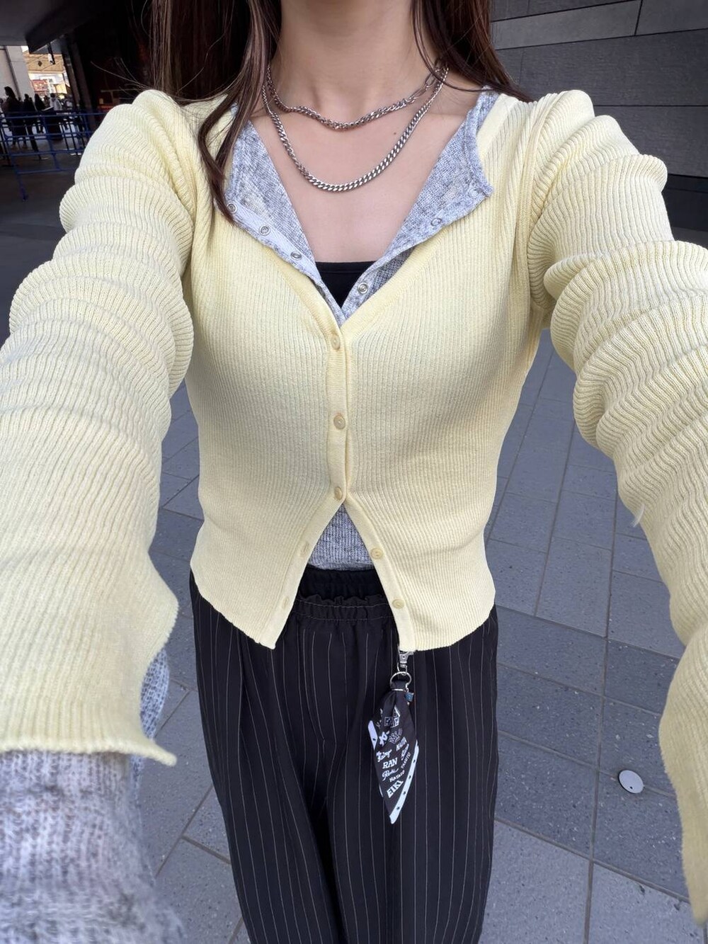 ブラック系のスラックス、グレー系のTシャツ/カットソーを着用したレディースの春コーディネートの2枚目の写真