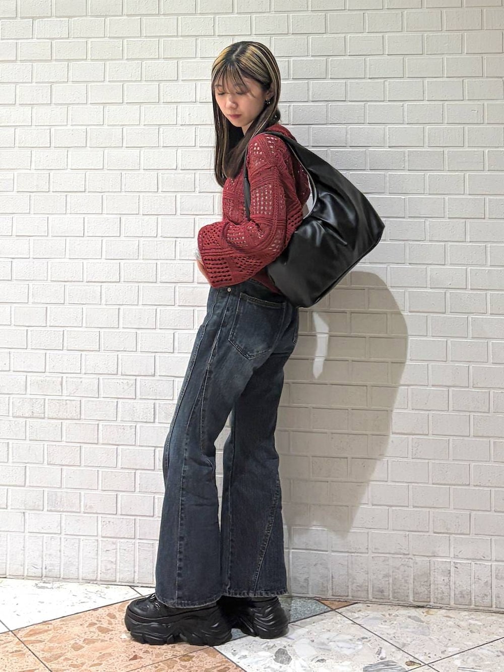 ブラック系のスニーカー、ブルー系のデニムパンツ、ブラック系のトートバッグを着用したレディースの春コーディネートの4枚目の写真