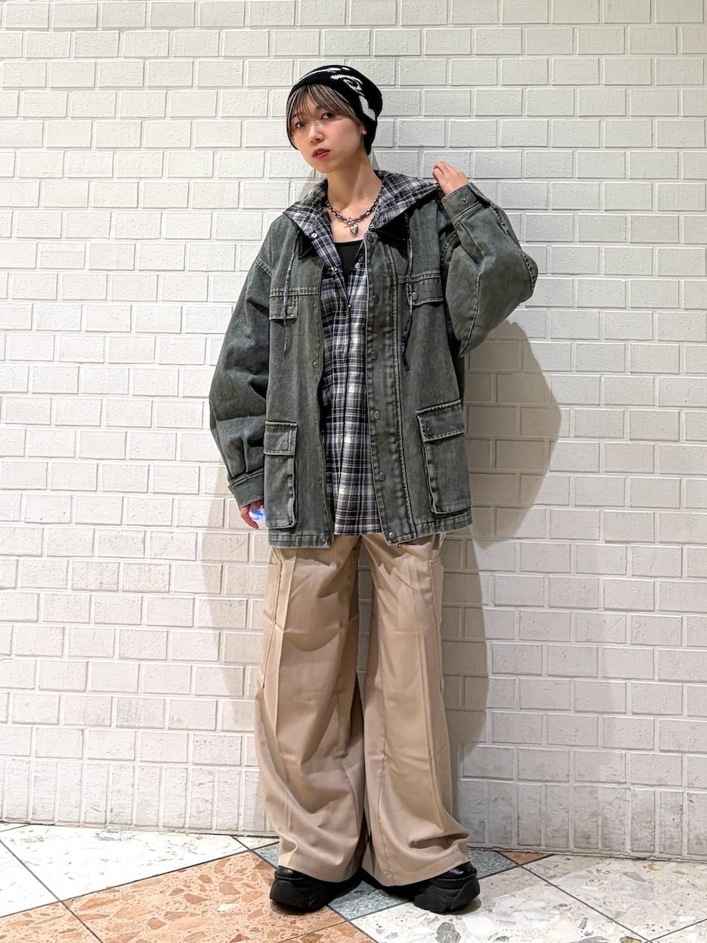 ブラック系のブーツ、ベージュ系のスラックス、ブラック系のシャツ/ブラウスを着用したレディースの春コーディネートの4枚目の写真