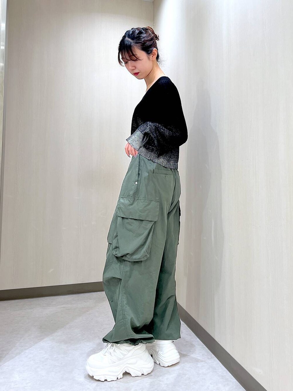 グリーン系のカーゴパンツ、ホワイト系のスニーカー、ブラック系のカーディガン/ボレロを着用したレディースの夏コーディネートの2枚目の写真