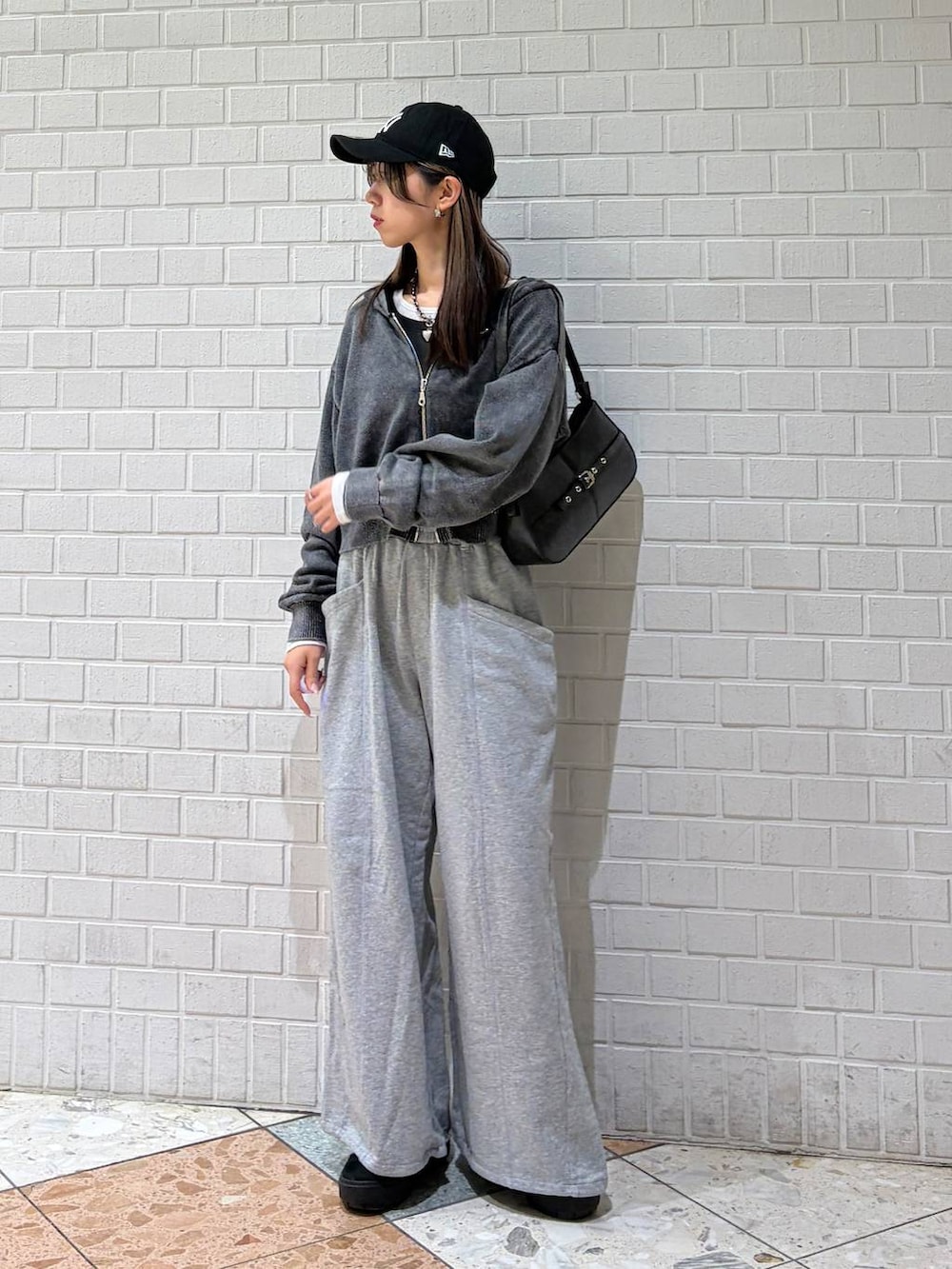 ブラック系のハンドバッグ、グレー系のスウェットパンツ、グレー系のパーカーを着用したレディースの冬コーディネートの4枚目の写真