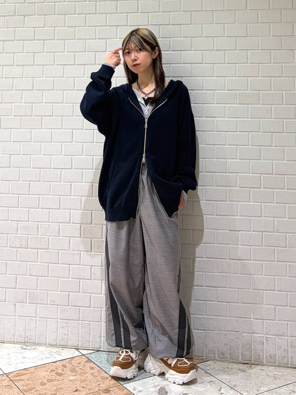 ベージュ系のスニーカー、ブルー系のパーカー、グレー系のその他パンツを着用したレディースの春コーディネートの7枚目の写真