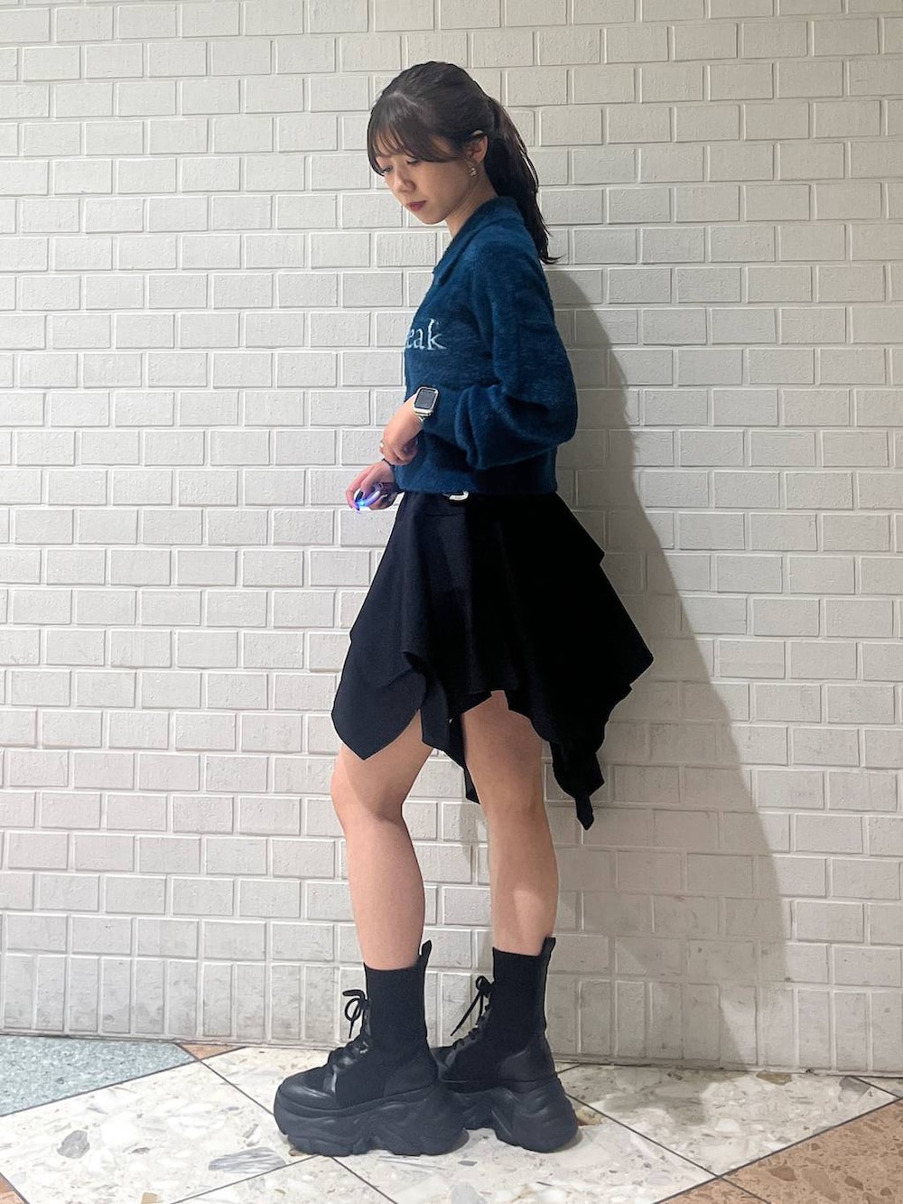 ブラック系のブーツ、ブラック系のベルトを着用したレディースの秋コーディネートの2枚目の写真