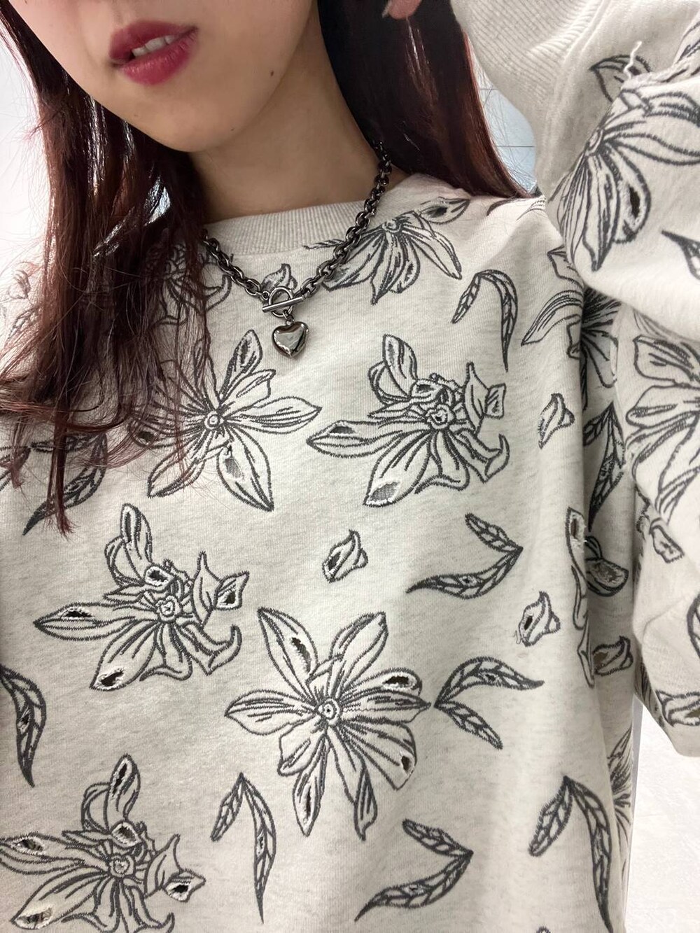 ブルー系のデニムパンツ、グレー系のスウェット、ブラック系のネックレスを着用したレディースの冬コーディネートの3枚目の写真