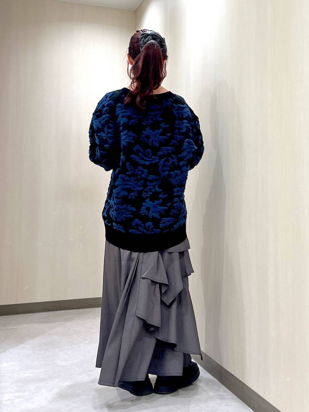 ブラウン系のスカート、ブルー系のキャミソール、ブラック系のカーディガン/ボレロを着用したレディースの冬コーディネートの3枚目の写真