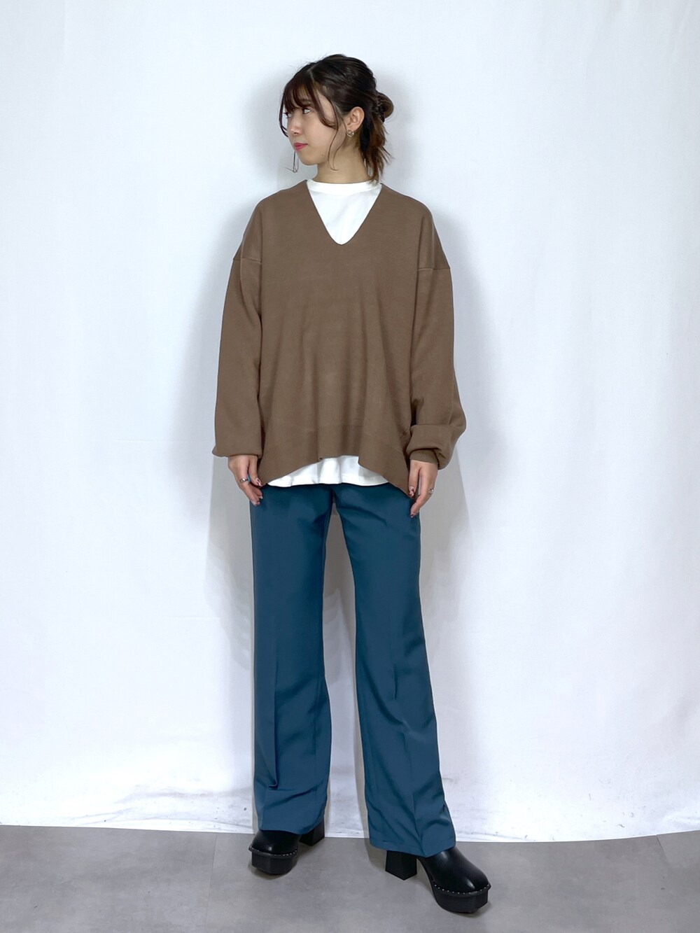 ホワイト系のTシャツ/カットソー、ブラウン系のニット/セーター、ブルー系のスラックスを着用したレディースの冬コーディネートの3枚目の写真