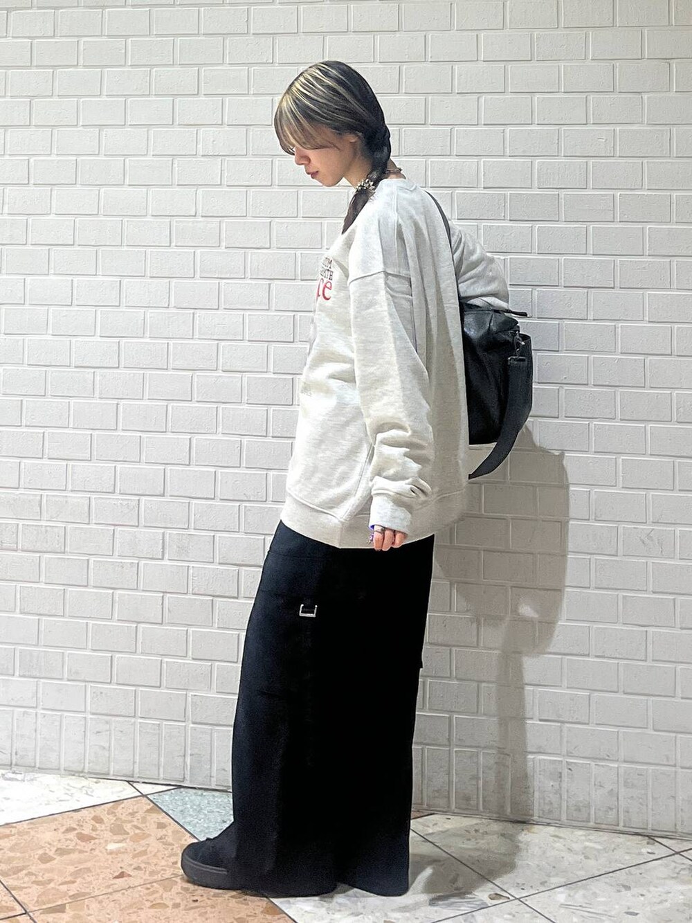 グリーン系のボストンバッグ、ブラック系のスラックス、グレー系のスウェットを着用したレディースの冬コーディネートの3枚目の写真