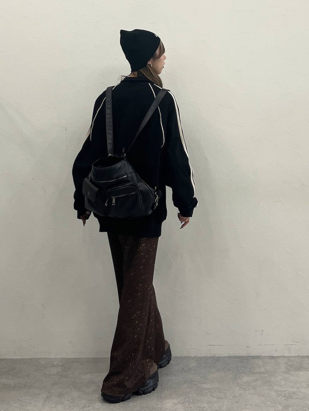 ブラウン系のブーツ、ブラック系のショルダーバッグ、ブラック系のジャージを着用したレディースの冬コーディネートの7枚目の写真