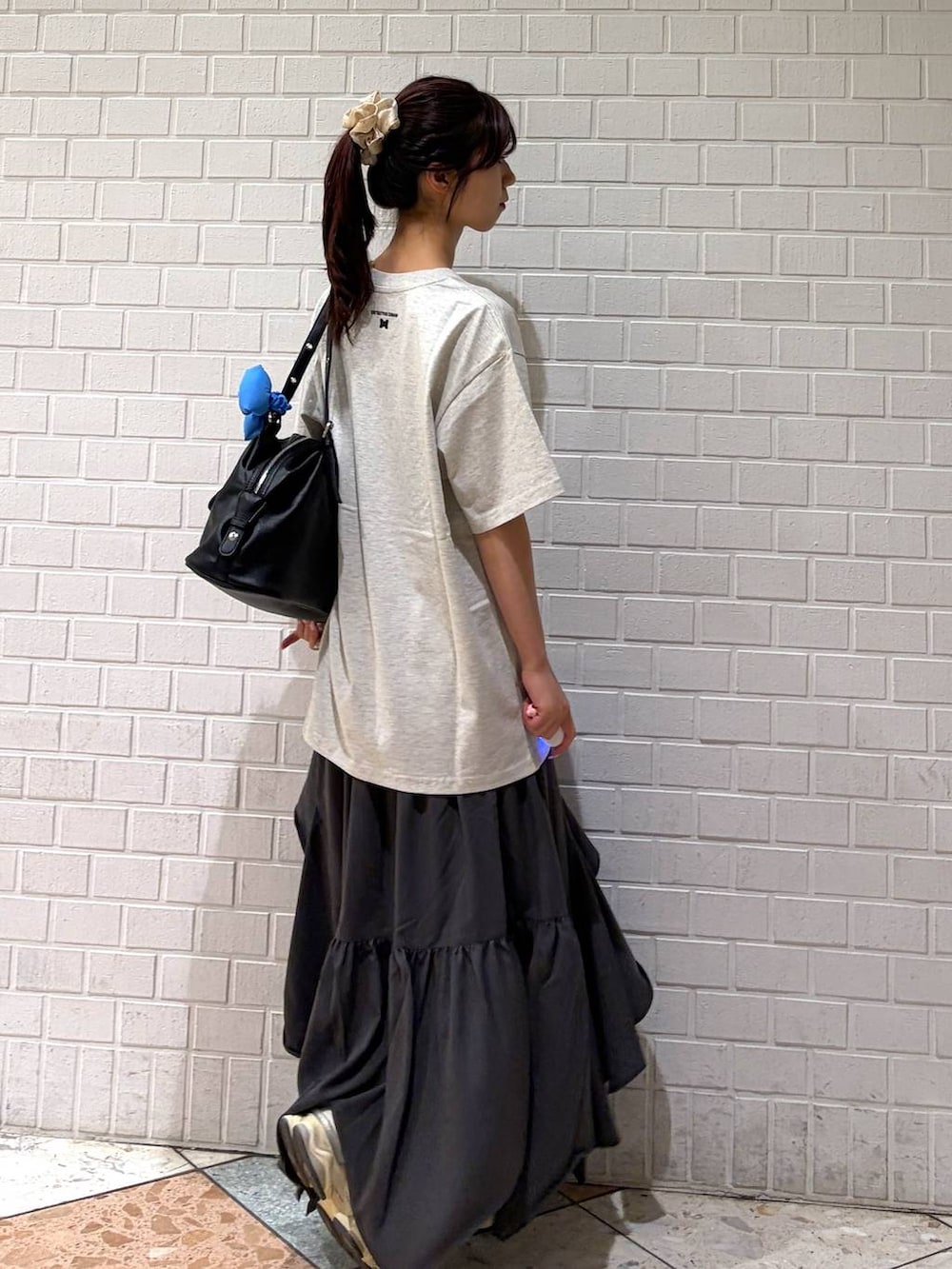グレー系のスカート、ブラック系のボストンバッグ、ホワイト系のTシャツ/カットソーを着用したレディースの春コーディネートの7枚目の写真