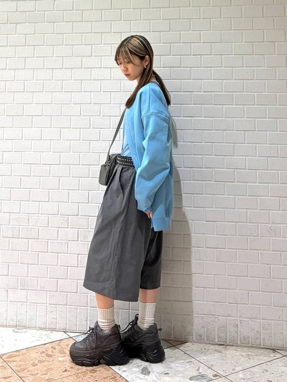 グレー系のスニーカー、グレー系のショルダーバッグ、グレー系のスラックスを着用したレディースの春コーディネートの5枚目の写真