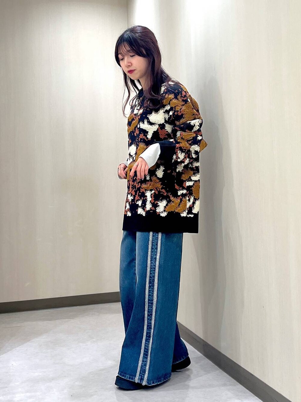 ブルー系のデニムパンツ、ブルー系のニット/セーター、ブラック系のネックレスを着用したレディースの冬コーディネートの4枚目の写真