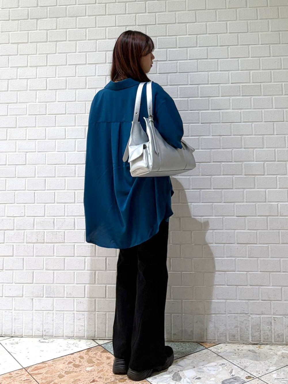 ブラック系のデニムパンツ、シルバー系のハンドバッグ、ブルー系のシャツ/ブラウスを着用したレディースの夏コーディネートの2枚目の写真